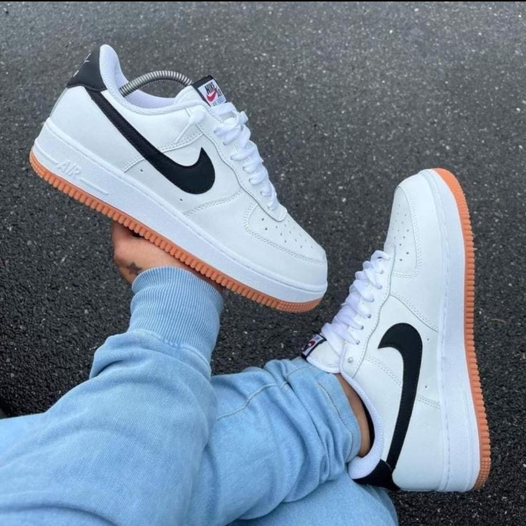 Zapatillas Nike Force One de moda en color blanco y negro, vista lateral, con detalles en la suela y marca visible.