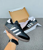 Zapatos Adidas Samba de moda en color negro con detalles en blanco, diseñados por Tula, en primer plano.