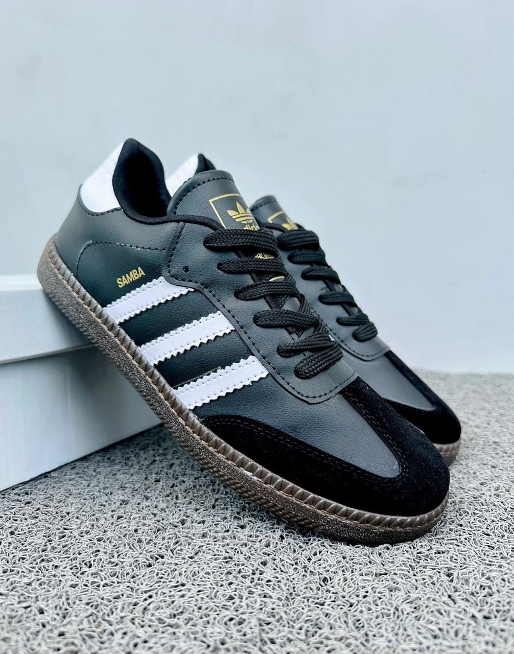 Zapatillas Adidas Samba de moda en color negro con detalles blancos, marca Tula, vista frontal y detalles de diseño.