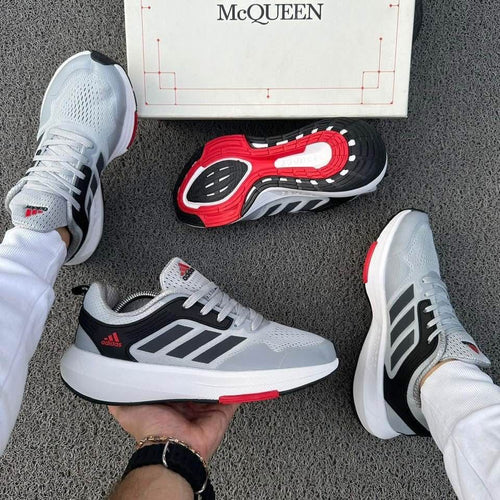Zapatillas Adidas Ultra Boost de moda en color negro con detalles blancos, vistas desde el lateral, marca Taboada.