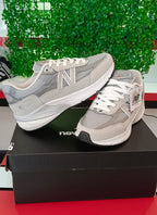 Ropa deportiva Valkyrie y zapatillas New Balance 990 en color gris, vista frontal con detalles de tela y suela blanca