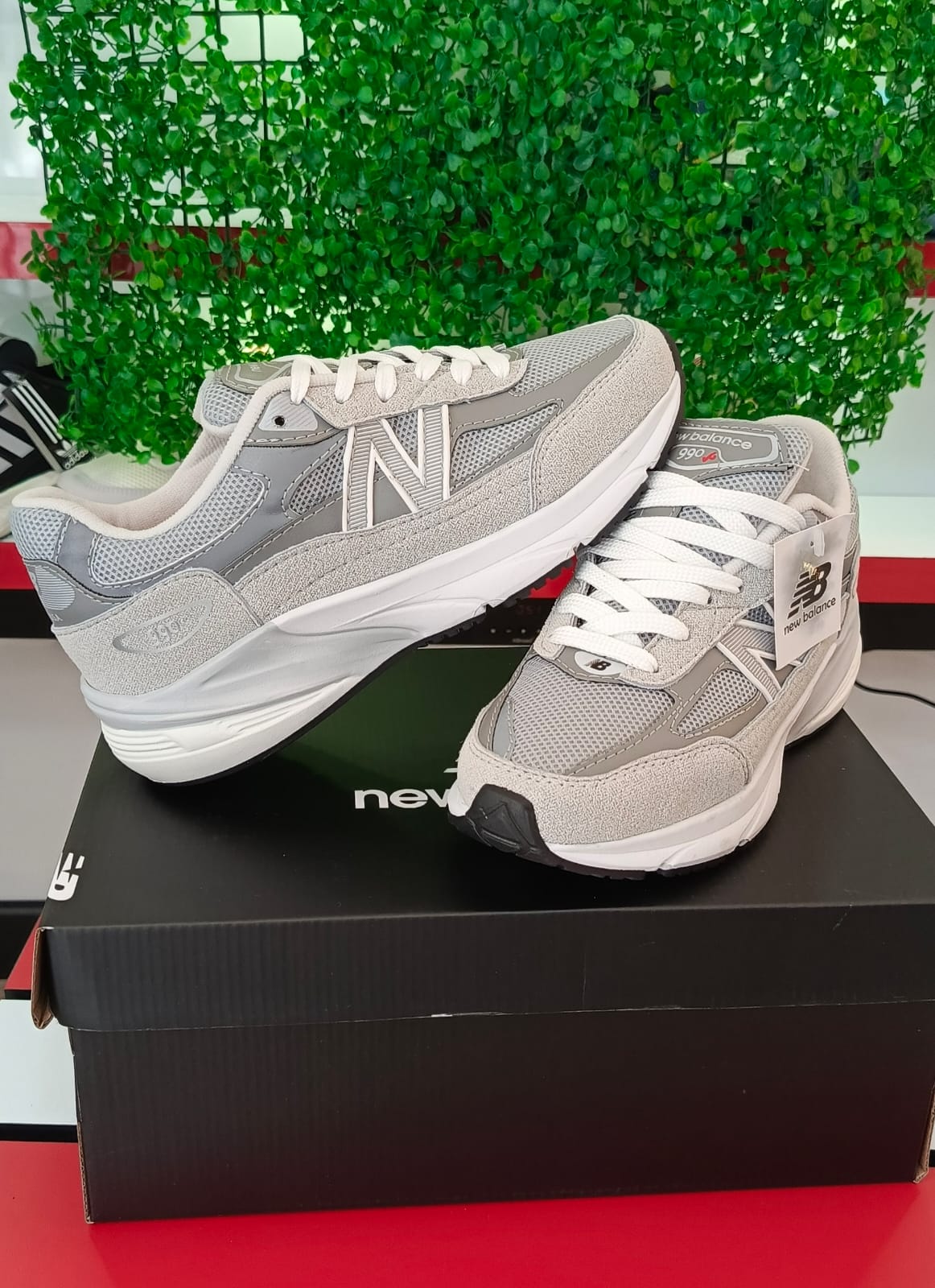 Ropa deportiva Valkyrie y zapatillas New Balance 990 en color gris, vista frontal con detalles de tela y suela blanca